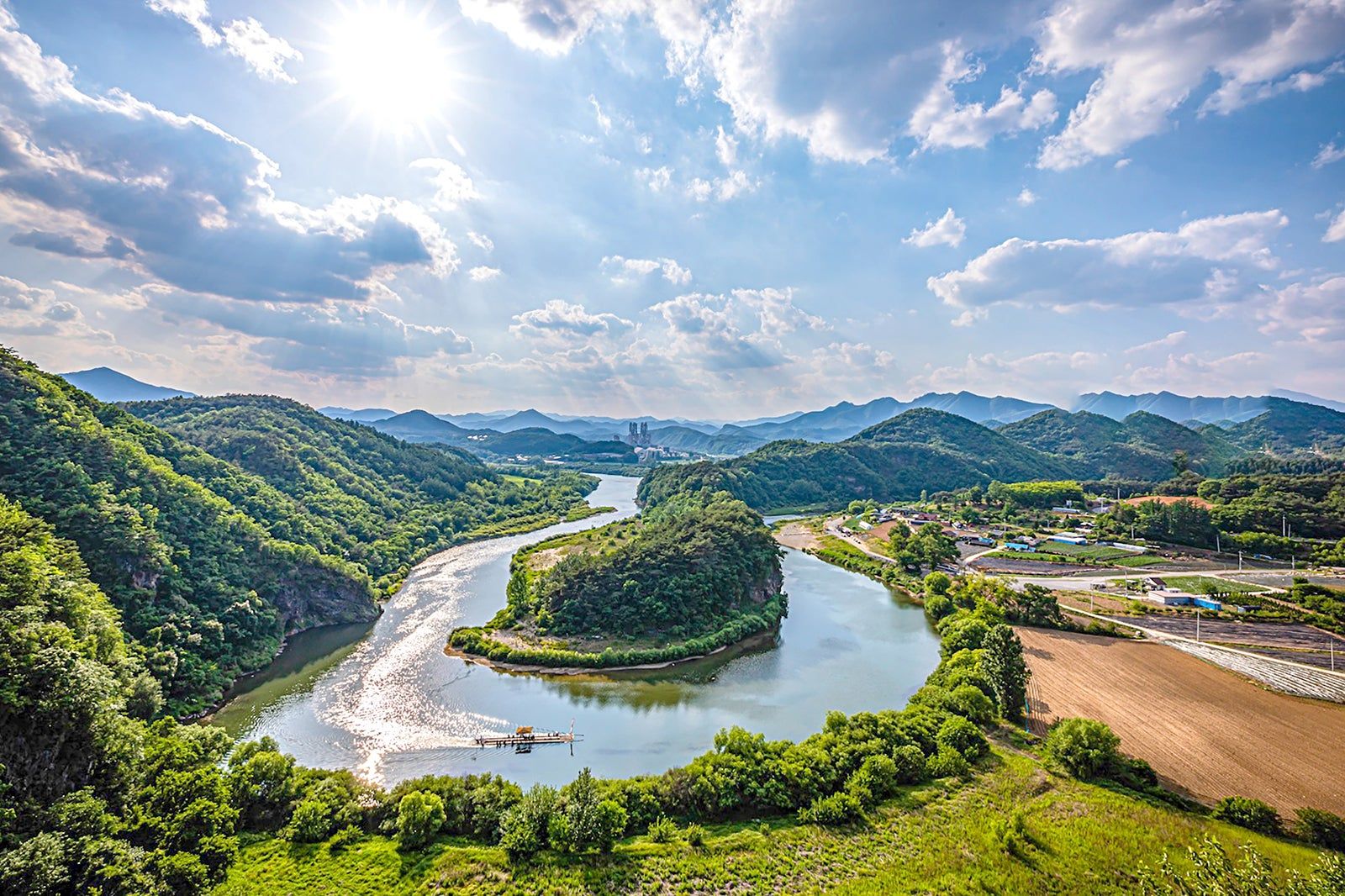 A river meandering through forested hills and farmland