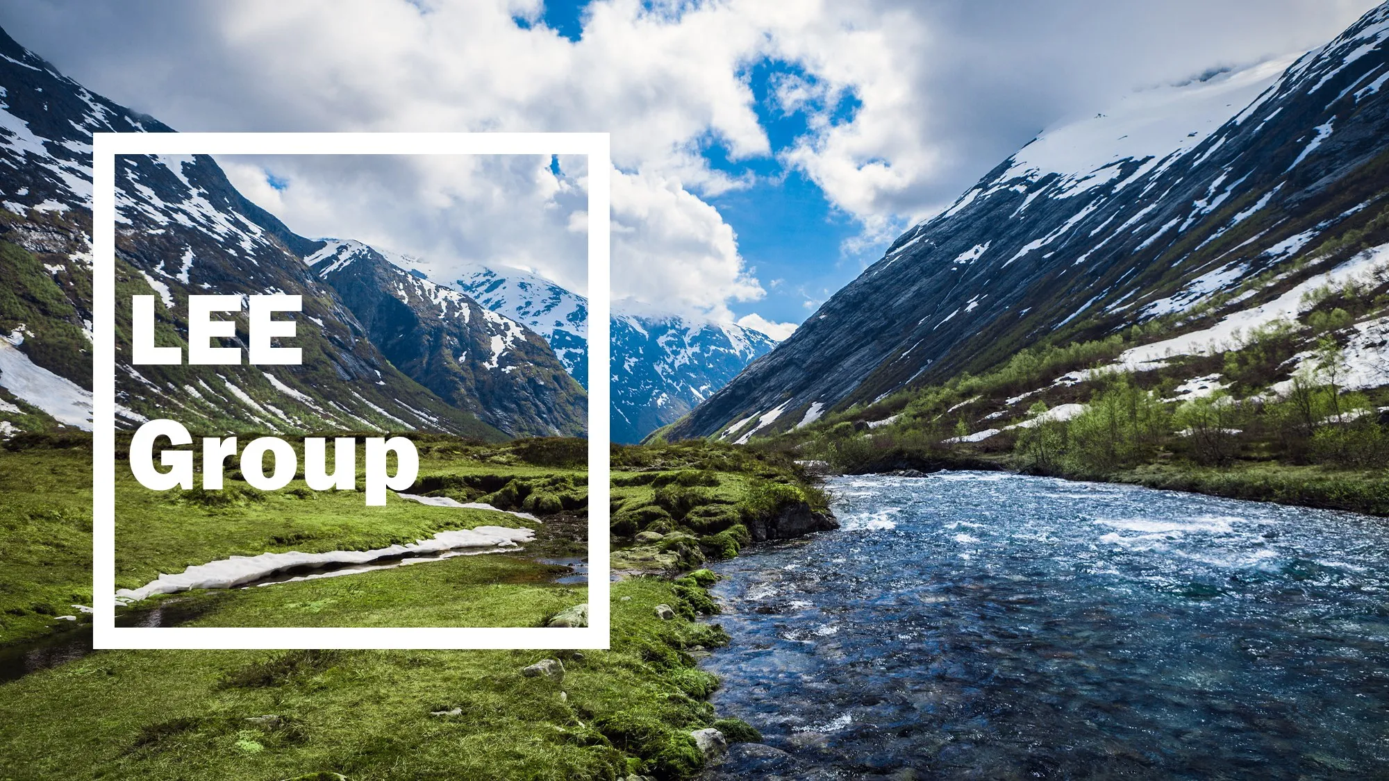 A river running through a green, snow-lined mountain valley, captioned LEE Group